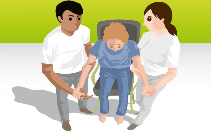 Mobilisation unterstützt durch zwei Pflegekräfte